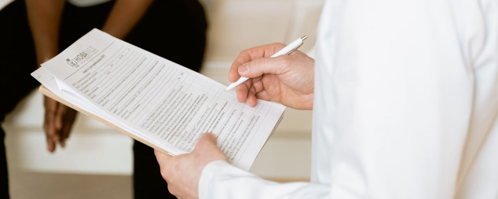 Profissional de saúde preenchendo ficha clínica durante atendimento